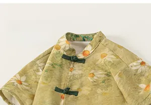Détail de l'imprimé marguerite et des boutons chinois traditionnels sur haut pour garçon