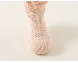 Détail macro des chaussettes en maille de coton rose avec motifs de losanges évidés