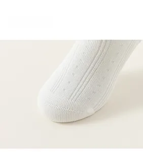 Gros plan sur le tissu en maille respirante blanche des chaussettes pour filles rayées