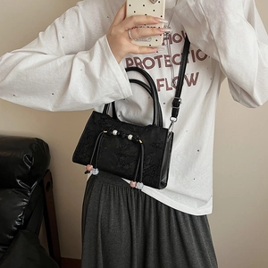 Elegant black jacquard bucket bag with floral pattern and handcrafted beaded pendant