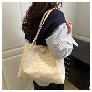 Model wearing a cream crocodile textured tote bag over the shoulder for daily style