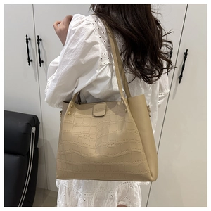 Detail of beige crocodile embossed tote bag showing large capacity and long straps