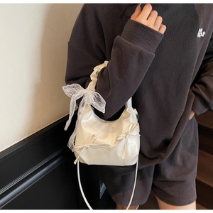 Détail du sac nuage blanc brillant avec nœuds en dentelle élégants et plis décoratifs