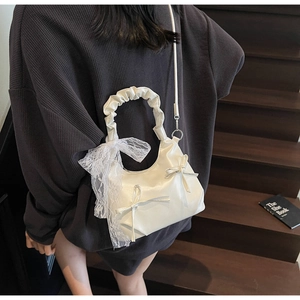 Détail du sac nuage blanc avec rubans en soie, nœuds en dentelle et poignée plissée