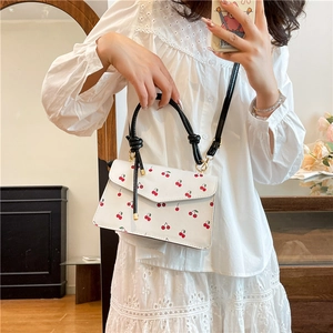 Sac bandoulière blanc chic avec imprimés cerises et poignée à nœud noir élégante