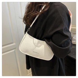 Detail of white hobo bag showing woven texture and elegant shoulder strap on model