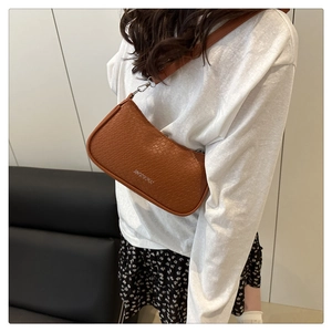 Close-up of brown woven texture shoulder bag with silver metal zipper and adjustable strap