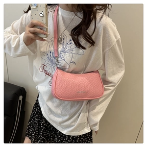 Detail view of pink woven texture shoulder bag with silver zipper in a daily life style