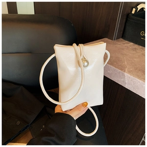 Detailed view of a mini white glossy crossbody phone bag with an elegant pearl decoration