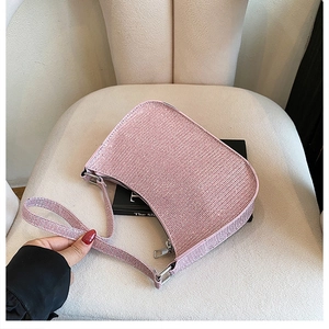 Detailed macro view of pink rhinestone studded luxury shoulder bag with shiny metal zipper