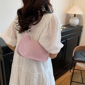 Sparkly pink rhinestone hobo bag worn on shoulder featuring a sleek woven texture
