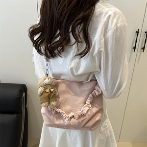 Pink pleated crossbody bag with bear pendant and stylish ruched shoulder strap for women