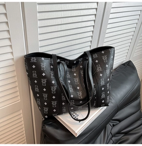 Vue détaillée du sac cabas noir avec motifs d'ours et texture en similicuir grainé