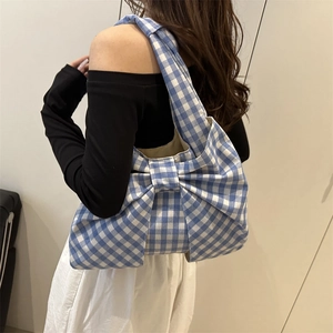 Blue and white checkered canvas tote bag with a large bow detail shown on shoulder
