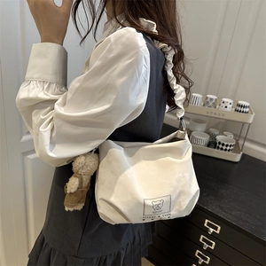 White minimalist cloud-strap shoulder bag with cute plush bear pendant accessory