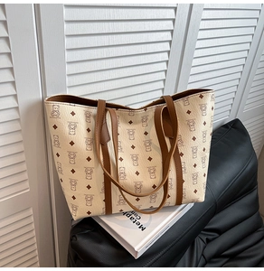 Gros plan détaillé d'un grand sac cabas beige imprimé ours posé sur un coussin doux