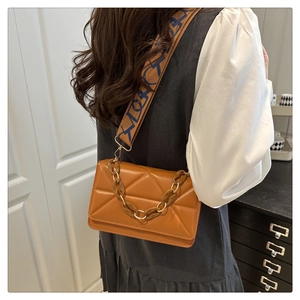 Detail of caramel brown crossbody bag featuring triangle quilting and jacquard strap