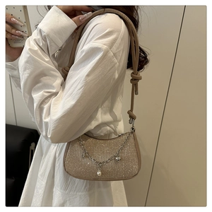 Détail du sac à paillettes champagne avec chaîne argentée, perles et bandoulière nouée