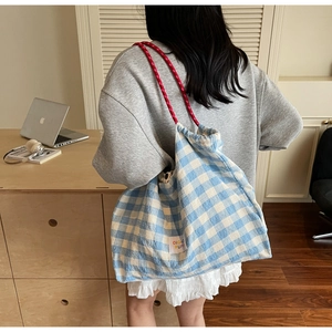 Détail du sac cabas en toile à carreaux bleu et blanc avec anses en corde tressée rouge