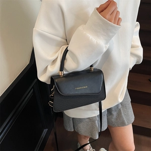 Elegant black crossbody shoulder bag with textured surface and gold metal accents