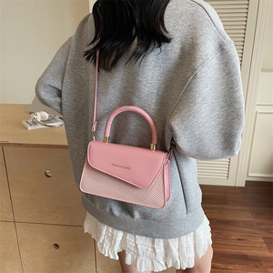 Elegant pink patchwork crossbody bag with leather and woven texture shown on a model