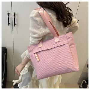 Détail du sac cabas en velours côtelé rose à rayures avec bandoulière et fermeture