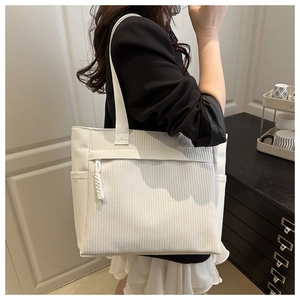 Détail du sac cabas en velours côtelé blanc avec texture verticale et poche zippée