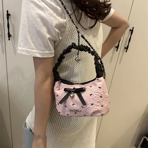 Pink pleated handbag with black bow and silver chain strap for a trendy look