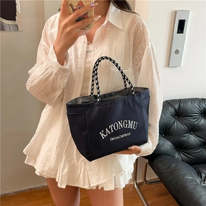 Navy canvas tote bag with woven rope handles and white lettering for casual daily commute