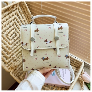 Detailed view of mini cream backpack with dachshund print on a rustic wicker chair