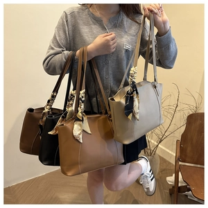 Detailed view of large capacity tote bags in multiple colors with silk scarf decorations