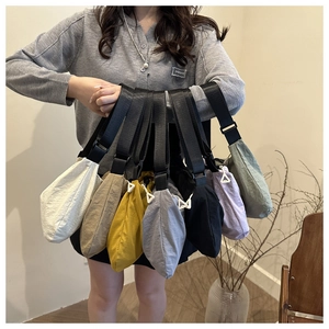 Collection of nylon crescent crossbody bags in seven vibrant colors with adjustable straps