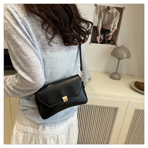 Details der eleganten schwarzen Schultertasche mit goldener Schnalle und Lederriemen