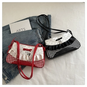 Detail showing red and black plaid baguette bags with lace trim and heart charm