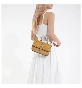 Détail du sac à main rectangulaire en paille et cuir avec poignée artistique en métal