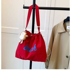 Red canvas shoulder bag with blue Beach text and a cute toast plush pendant