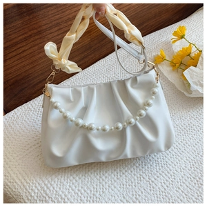 Detail view of white ruched cloud bag with large pearl chain and yellow silk handle