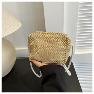 Détail d'un petit sac bandoulière en paille tressée avec texture naturelle et cordon