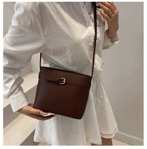 Detail of dark brown leather bucket bag with silver hardware and FANYISCA logo imprint