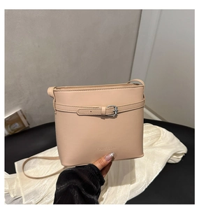 Detail shot of the FANYISSA logo and elegant belt buckle on this beige bucket bag