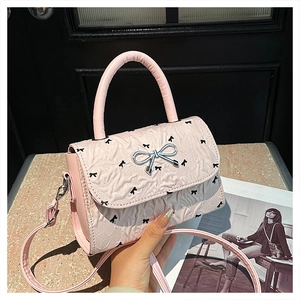 Détail du sac à bandoulière rose texturé avec boucle en argent en forme de noeud