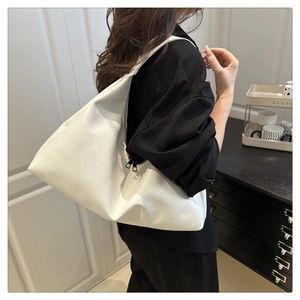 Close-up of white PU leather tote bag with black metal zipper and textured surface