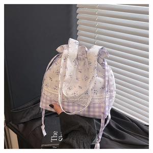 Close-up of floral and plaid drawstring bag with lace detail and purple fabric texture
