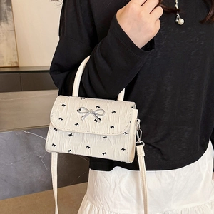 Sac à bandoulière crème pour femme avec imprimés nœuds noirs et boucle en métal argenté