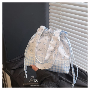 Detail of drawstring bento bag featuring floral gingham pattern and lace trim accents