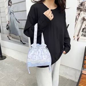 Floral and checkered drawstring bucket bag with lace trim and fabric handles
