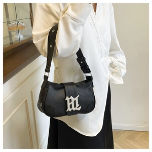 Detail of black vintage PU leather baguette bag with silver metal buckle and eyelet strap