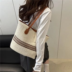 Large woven tote bucket bag in beige with brown leather handles and decorative lace trim