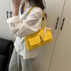 Sac polochon jaune en similicuir avec deux poches avant et des nœuds en dentelle sur les bretelles