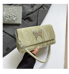 Detail of light green marble texture shoulder bag with silver butterfly clasp decoration